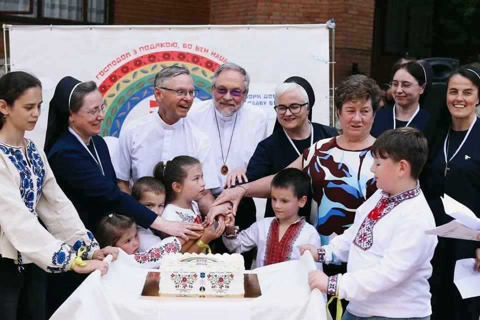 Children, clergy, and religious sisters gather for a celebration.