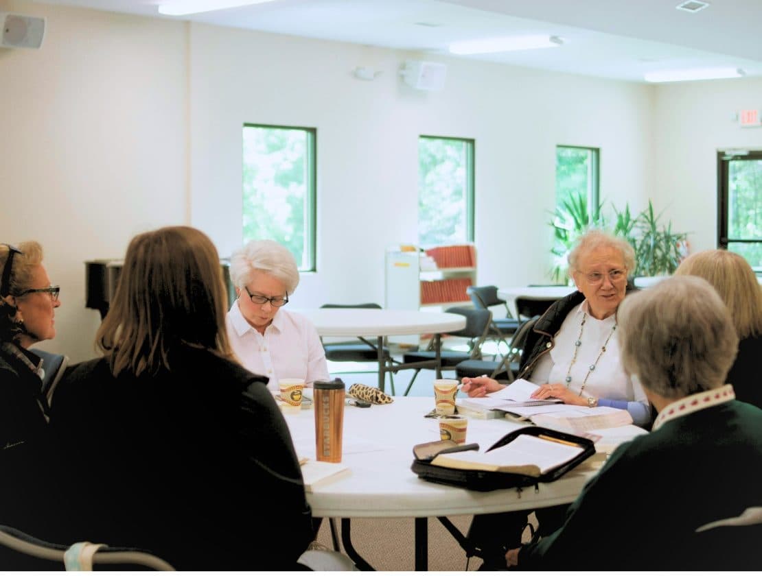 Parishioners gather around a table for thoughtful faith study and fellowship